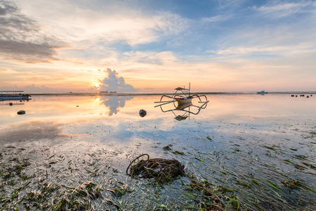 Holiday in Bali, Indonesia - Reflection Sunrise in Tanjong Benoa with boatの写真素材