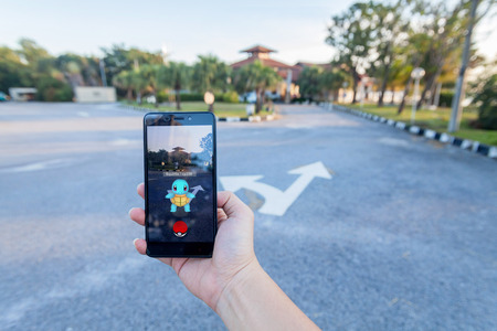 California, United States - July 30, 2016: Close up of a man holding a unbranded smartphone while playing Pokemon Go gameのeditorial素材