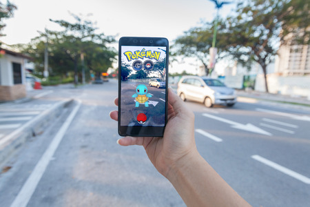 California, United States - July 30, 2016: Close up of a man holding a unbranded smartphone while playing Pokemon Go gameのeditorial素材