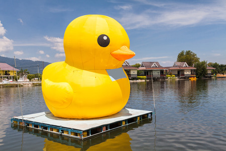Huge yellow balloon duck on top of lake or seaの写真素材