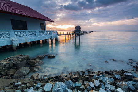 Sunrise by shore with rock foreground for backgroundの写真素材