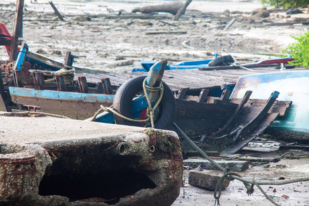 Broken abandoned fishing boat by the shoreの写真素材