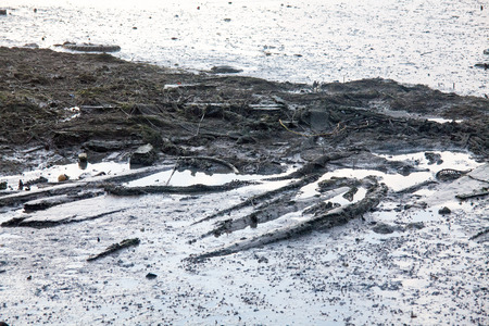Dirty muddy beach showing a dump site