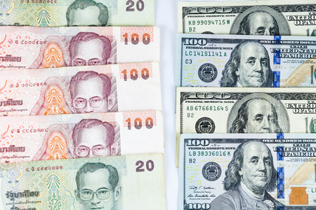 Close up view of US Dollar and Thai Baht indicating strong currency exchange rate