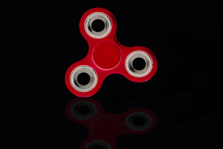 Fidget Spinner in black isolated background for stress release during workの写真素材