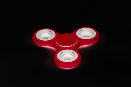 Fidget Spinner in black isolated background for stress release during workの写真素材