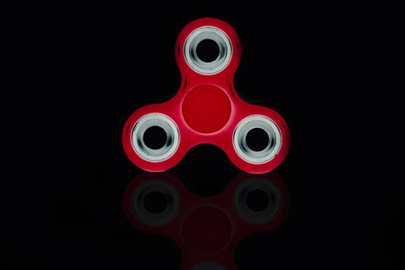 Fidget Spinner in black isolated background for stress release during workの写真素材