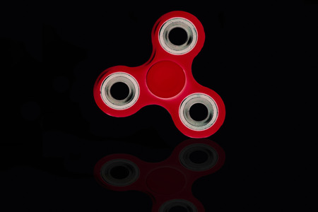 Fidget Spinner in black isolated background for stress release during workの写真素材