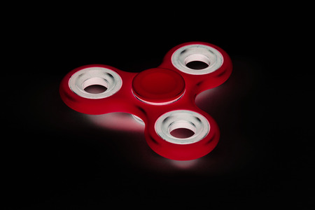 Fidget Spinner in black isolated background for stress release during workの写真素材