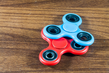 Fidget Spinner in wooden isolated background for stress release during workの写真素材