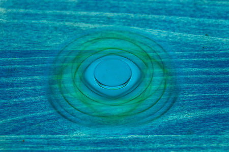 Fidget Spinner in fluorescent UV glowing isolated background for stress release during workの写真素材