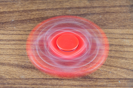Fidget Spinner in wooden isolated background for stress release during workの写真素材
