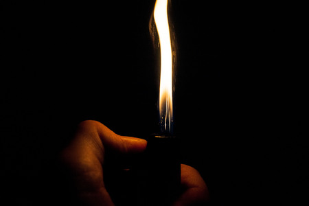 Close up view of real sparking light from lighter in dark black backgroundの写真素材