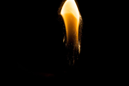Close up view of real sparking light from lighter in dark black backgroundの写真素材