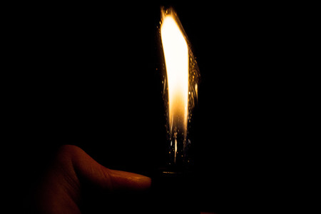 Close up view of real sparking light from lighter in dark black backgroundの写真素材