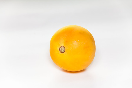 Orange tomato view in close up with blur isolated white backgroundの写真素材