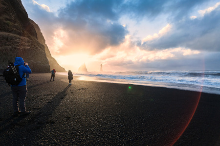 Reynisfjara or better known as Black Sand beach view during sunrise with photographers