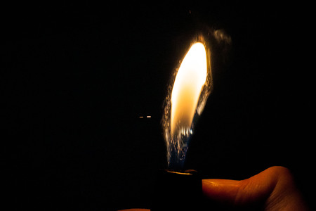 Close up view of real sparking light from lighter in dark black backgroundの写真素材