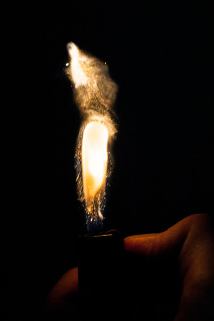 Close up view of real sparking light from lighter in dark black backgroundの写真素材