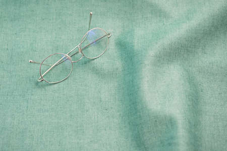 Eyeglasses desk concept aqua menthe fabric light green with copy spaceの写真素材