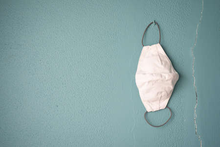 White crafted face mask on a green aqua wallの写真素材