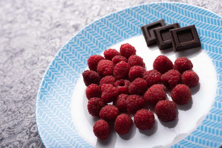 Heart of raspberry and chocolate squares on white and blue dish. St Valentine 'day dessert. High...