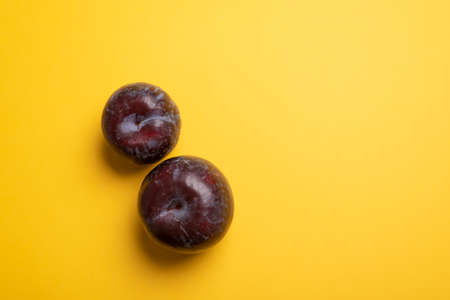 Two blue plums and big yellow copy space area. Ready for adding textの写真素材