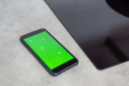 Smartphone tutor cooking class or browsing website next to kitchen stove in close-up. Person consulting recipe concept. Online cooking tutorial instructions. Digital display montage readyの写真素材