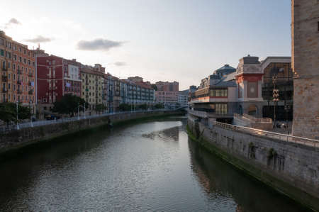 Bilbao, Euskal Herria, Spain - 09 04 2018: Nervion river at Ribera market and San Anton church at sunset. Clear blue sky and few small clouds offer copy spaceのeditorial素材