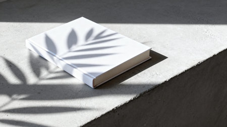 White book with leaf shadow on concreteの素材