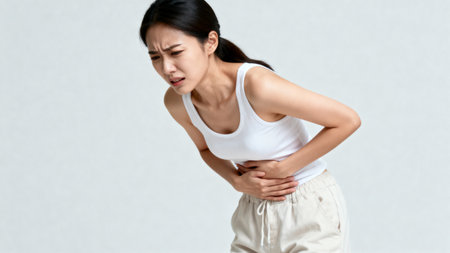 Young asian woman suffering from stomach ache. Health care concept.の素材