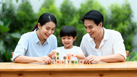 Happy asian family playing wooden blocks in the garden. Father, mother and son having fun together.の素材