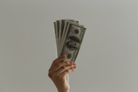 Hand holding a lot of dollars on a white background, business conceptの写真素材