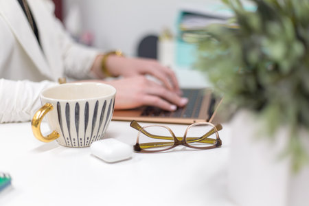 Close-up of a business woman working on a laptop at officeの写真素材