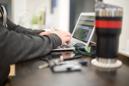 Man working on a laptop in his home office. Selective focus.の写真素材