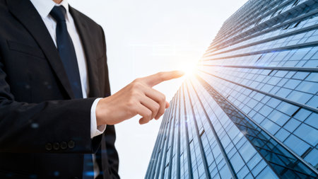 Close up of businessman pointing with finger at modern skyscrapers backgroundの素材