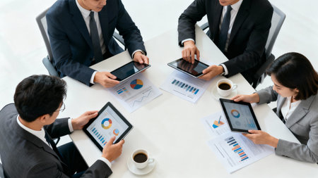 Business people discussing the charts and graphs showing the results of their successful teamworkの素材