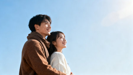 Couple in warm clothing under blue skyの素材