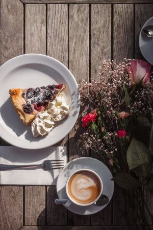 A cup of coffee with a piece of pie on a wooden tableの写真素材