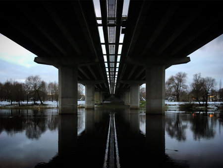 Bridge over the river in the evening. The bridge is reflected in the water.の写真素材