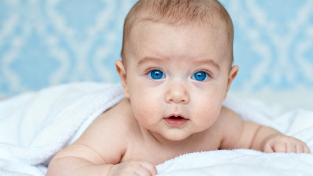 Baby with blue eyes wrapped in towelの素材