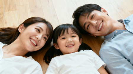 family of three smiling on floorの素材
