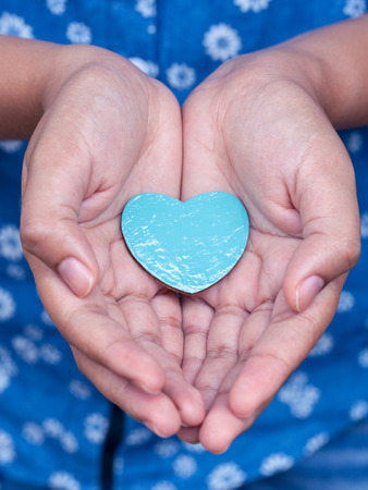 Girl holding wood shape of heart . Concept for giving love.の写真素材