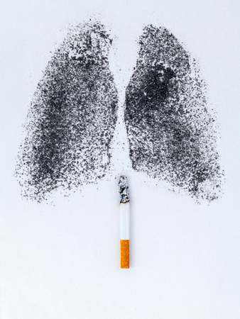 Shape of lungs with charcoal powder and cigarette on white backgroundの写真素材