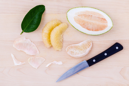 Fresh pomelo cutting and peeled on the wooden background.の写真素材