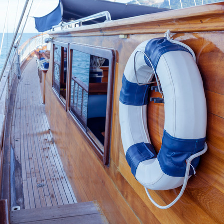 Lifebuoy on the wall of sailboat with rope.