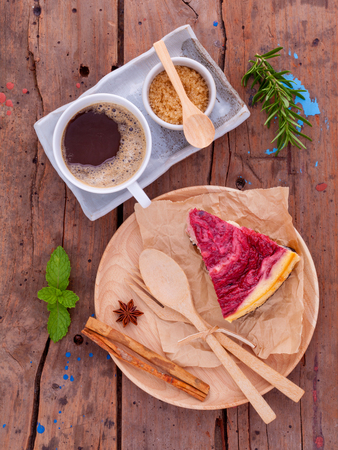 Homemade raspberry cake with cup of coffee on wooden background.の写真素材