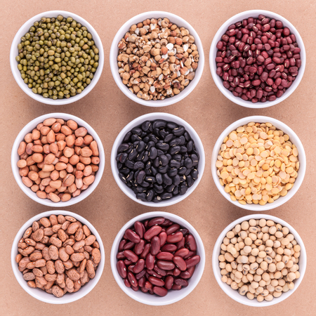 Mixed beans and lentils in the white bowl  on brown background. mung bean, groundnut, soybean, red kidney bean , black bean ,red bean,green bean,millet and brown pinto beans .の写真素材