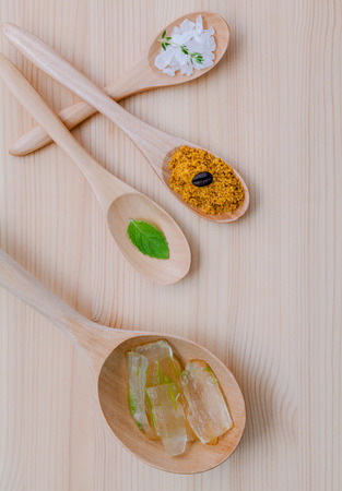 Alternative skin care and homemade scrubs aloe vera and sea salt in wooden spoons  set up on wooden table.の写真素材