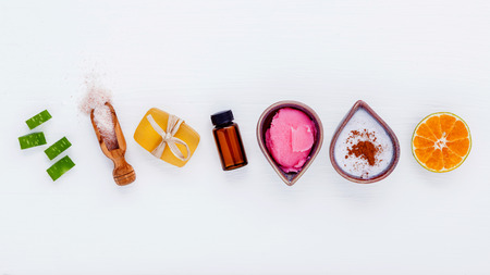 Homemade skin care and body scrubs with natural ingredients aloe vera ,orange slice,himalayan salt ,herbal soap and aromatic oils set up on white wooden background with flat lay.の写真素材